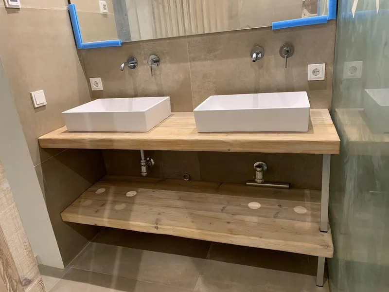 Obra: lavabos sobre encimera de madera, con el espejo aún protegido