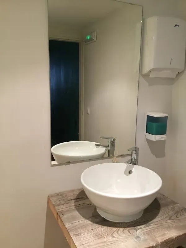 Lavabo sobre encimera de madera en el baño