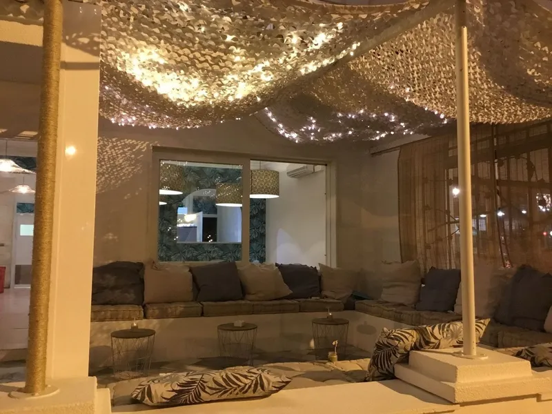 Zona cubierta con techo de luces y sofás bajos al anochecer