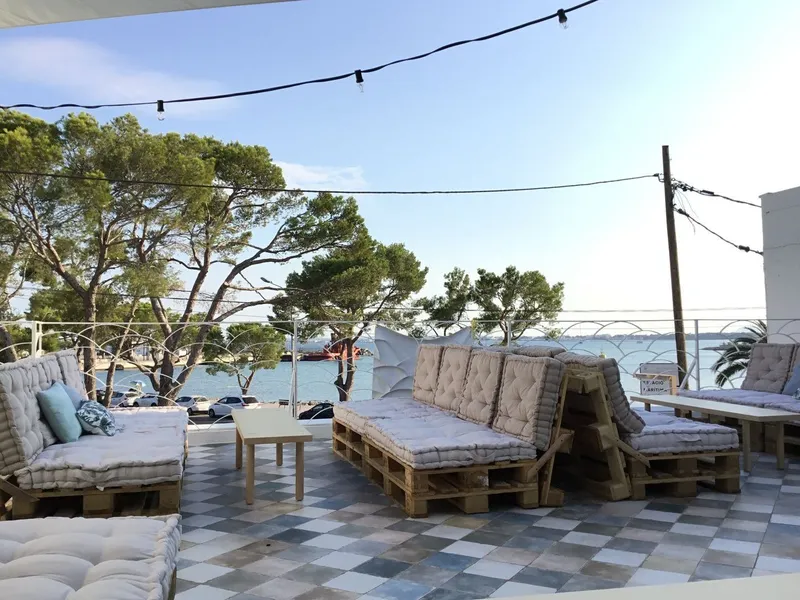 Terraza chill out con sofás de palés, guirnaldas de luz y vistas al mar