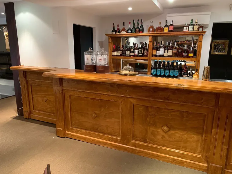 Antes: barra de madera natural con estanterías de botellas