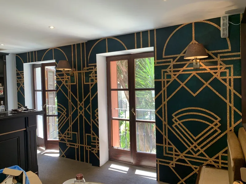 Después: la misma pared con revestimiento art déco verde y oro