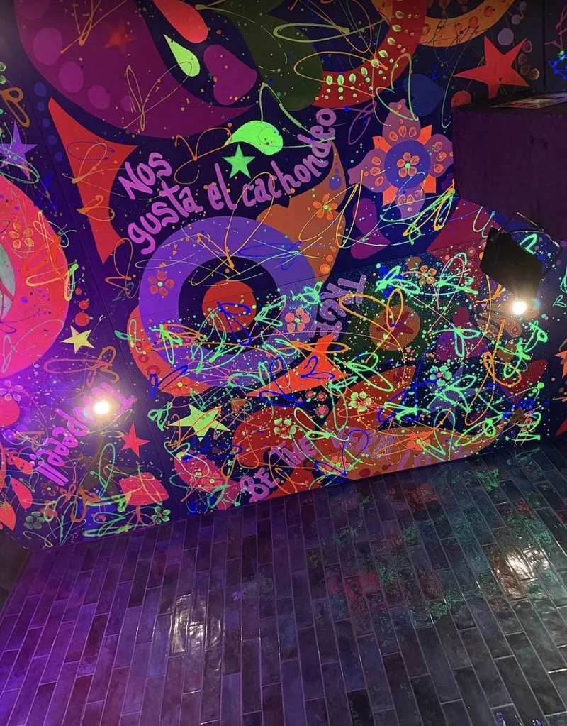 Pared pintada con colores fluorescentes y suelo de baldosa violeta