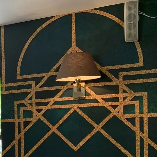 Green-and-gold art-deco wall finish with a wall light at The Downtown