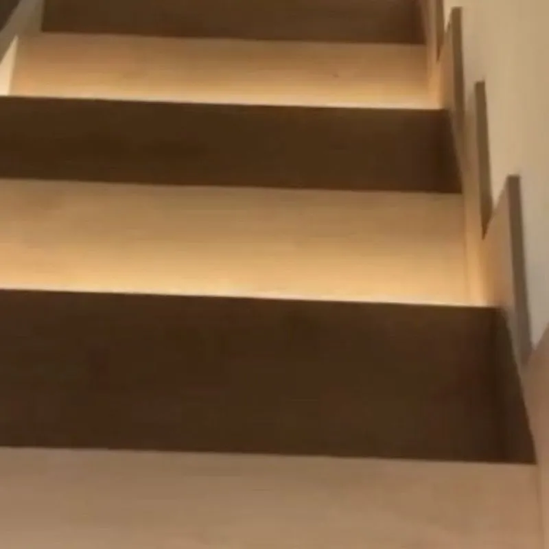 Peldaños de roble iluminados en la escalera de Portixol