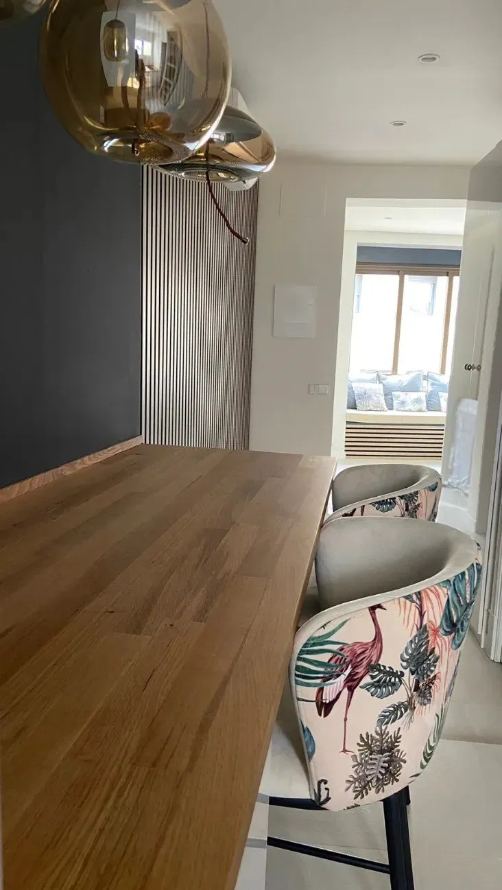 Barra de madera con taburetes estampados y lámparas de cristal ahumado