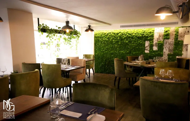 Sala del restaurante reformada, con butacas de terciopelo, muro de musgo y macetero colgante