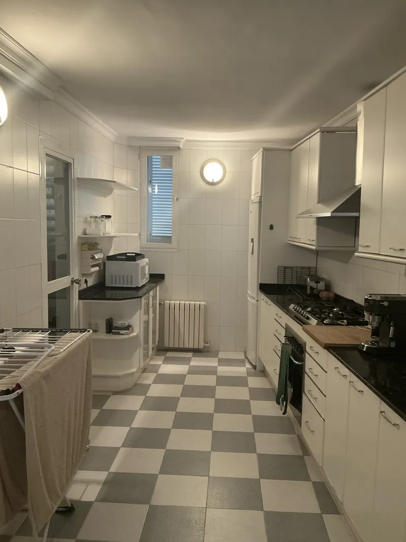 Estado actual: cocina con suelo de damero y muebles blancos