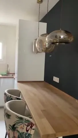 Fotograma del vídeo «después»: barra de madera con lámparas de cristal y sillas tapizadas