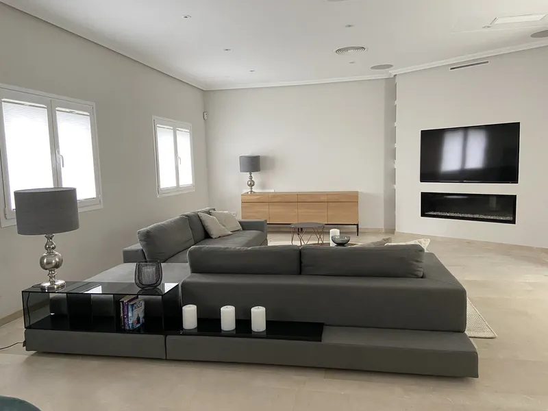 Antes: salón con pared lisa y aparador de roble