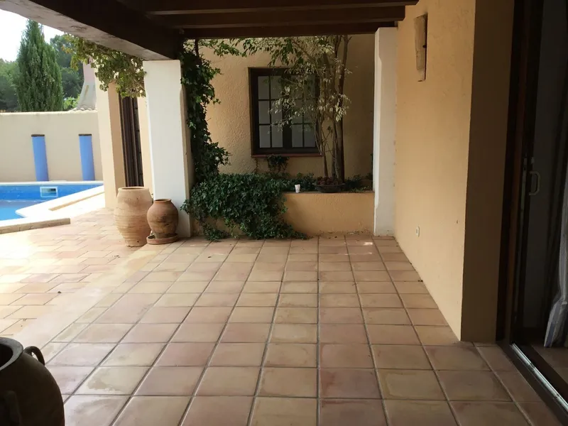 Antes: terraza cubierta vacía junto a la piscina