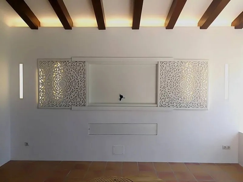 Después: pared del salón con dos paneles tallados y líneas de luz LED